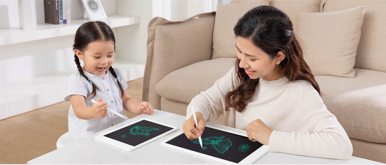 A young child and a young child playing a game on a tablet Description automatically generated with low confidence